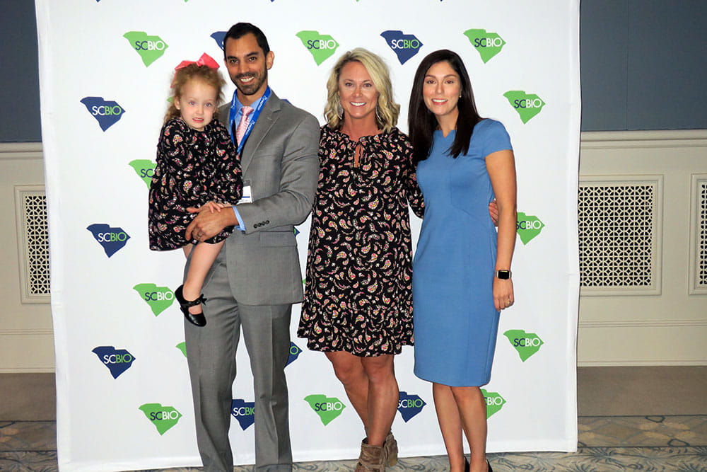 Dr. Ramin Eskandari holds the little girl he's known since she was born. Harper's mother Jenna Brown and MUSC's director of external affairs, Caroline Brown, stand beside them.