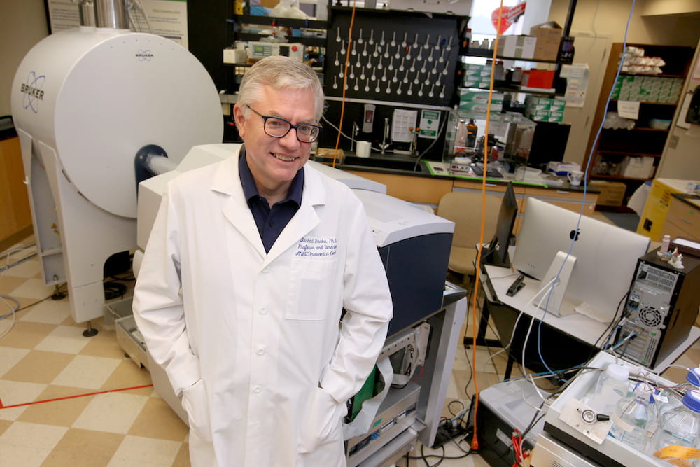 Dr. Richard Drake standing in front of the MALDI mass spectrometer.