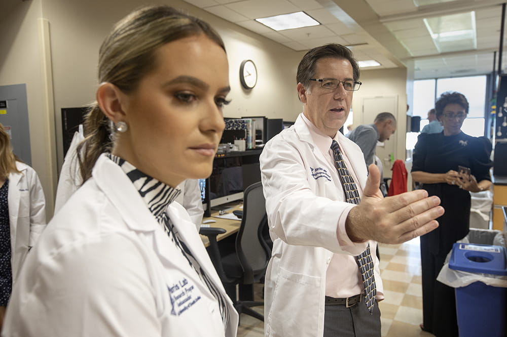 Miss America listens as researcher Chip Norris speaks and gestures