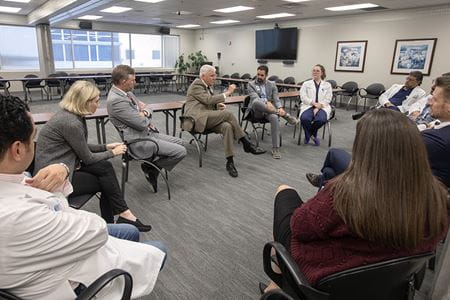 Cole is surrounded by dozens of health care workers as he answers questions in a conference room in Florence.