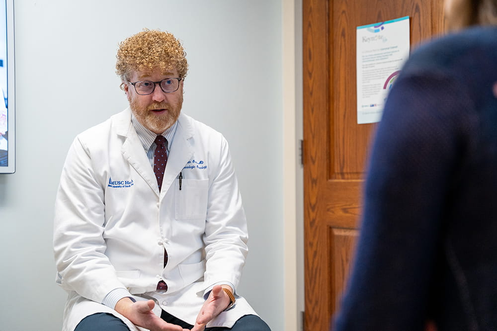 a gynecologic cancer doctor speaks with a patient in an exam room