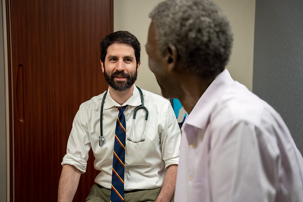 a doctor speaks with a patient in an exam room
