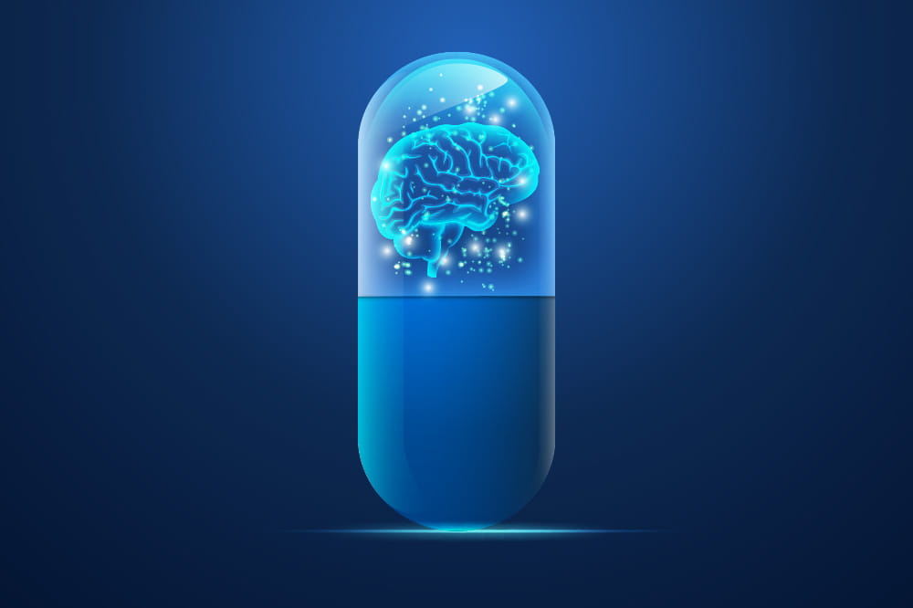 an illustration of a pill with a brain surrounded by glowing points of light inside the top half of the pill