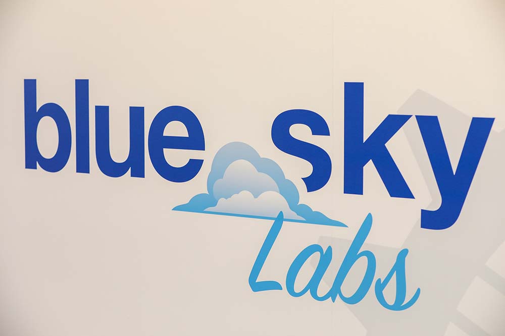 The words Blue Sky Labs with a cloud and sky illustration.