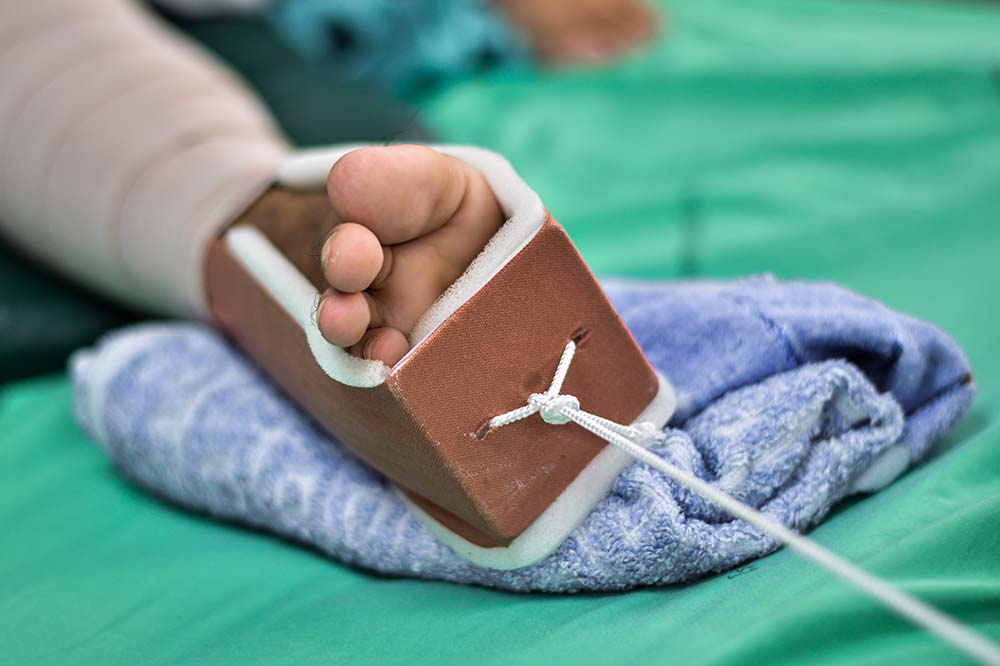 A foot in a brown casing with a string attached to it.