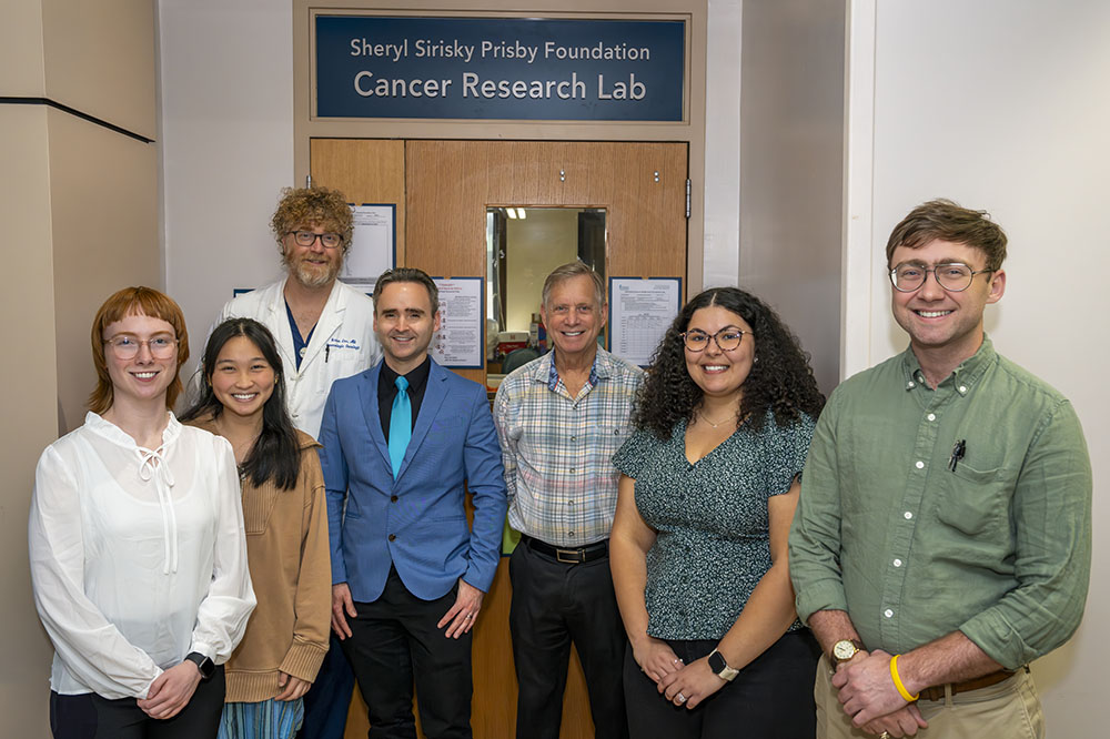 group photo in front of entrance to cancer research lab
