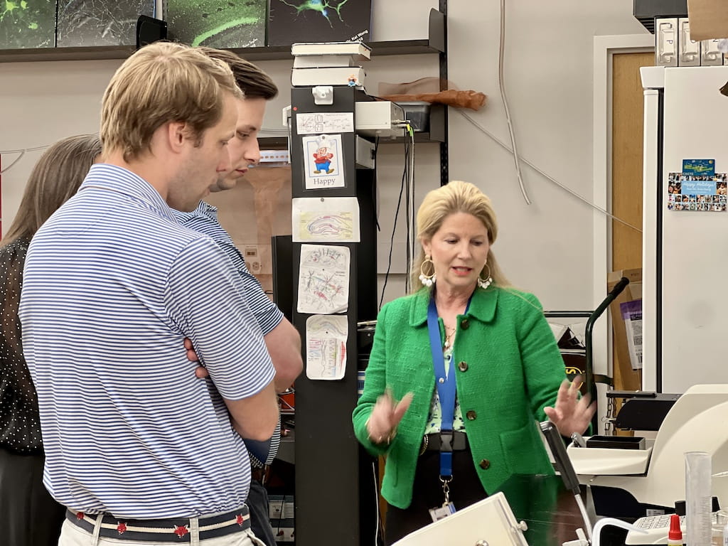 Dr. Lori McMahon gives Walker Truluck (left) and Grant Singleton (middle) a tour of her lab.