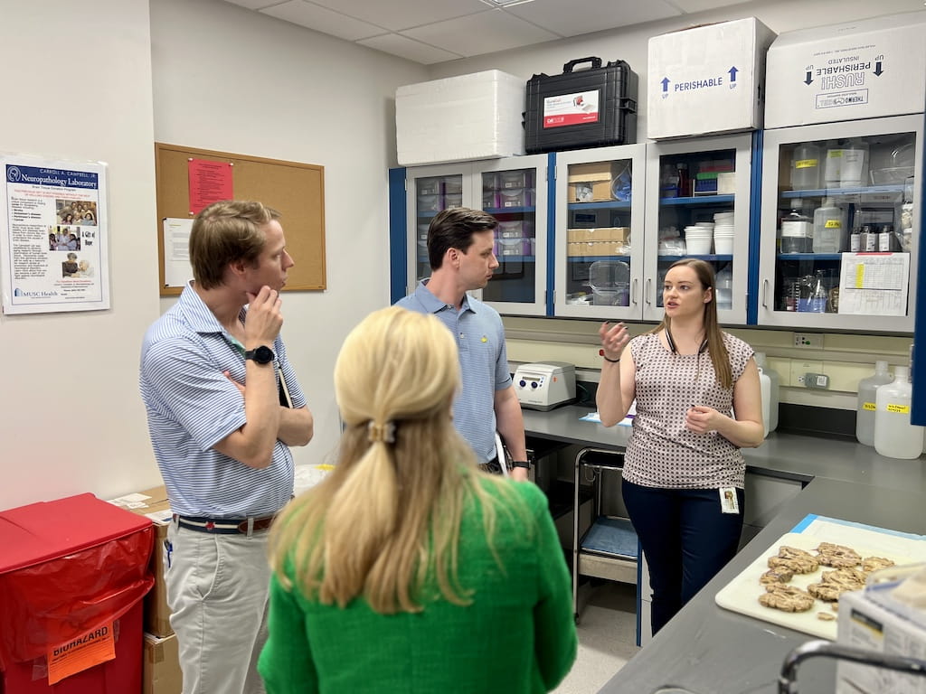 Dr. Lori McMahon (front), Walker Truluck (left), and Grant Singleton (middle) talk to Michelle Ackerman (right) about brain autopsies for definitive diagnosis of Alzheimer’s and other neurodegenerative diseases.
